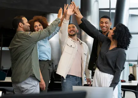 Profissionais com boa employee experience, felizes e dando as mãos - Imagem de Freepik