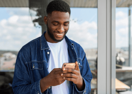 Como preservar assiduidade no trabalho Homem olhando celular para verificar assiduidade no trabalho - Imagem de Freepik