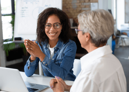 Trabalhadoras conversando sentadas em mesa, praticando cultura de feedback - Imagem de Freepik