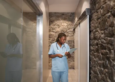 Enfermeira andando em corredor de hospital e conferindo a escala de plantão - Imagem de Freepik