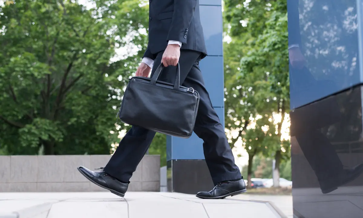 Pessoa indo embora da empresa, segurando maleta, caso de redução da jornada de trabalho - Imagem de Freepik