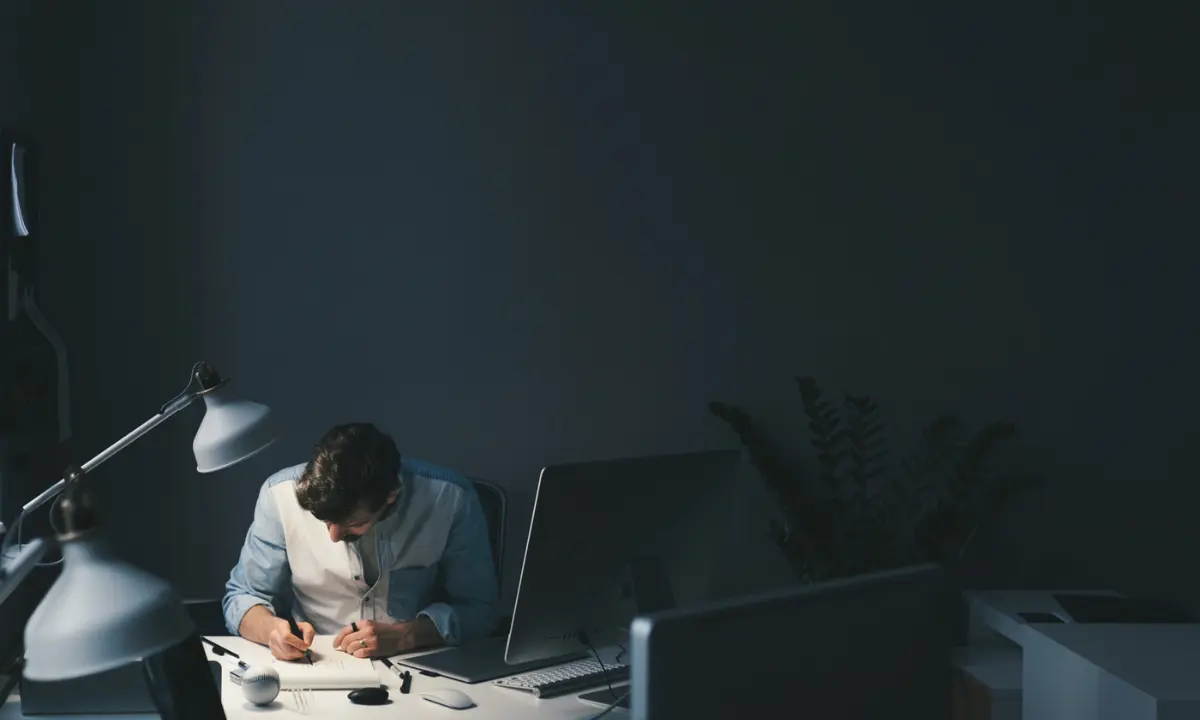 Profissional trabalhando no computador à noite, sofrendo excesso de trabalho - Imagem de Freepik