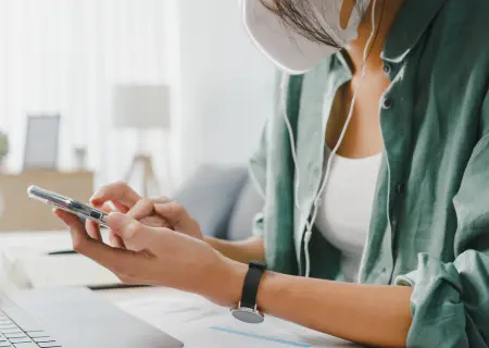 Profissional de máscara mexendo em celular - Imagem de Freepik