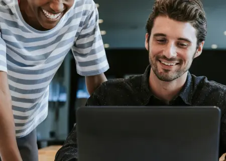 Dois profissionais mexendo em laptop em escritório montando turnos de trabalho - Imagem de Freepik