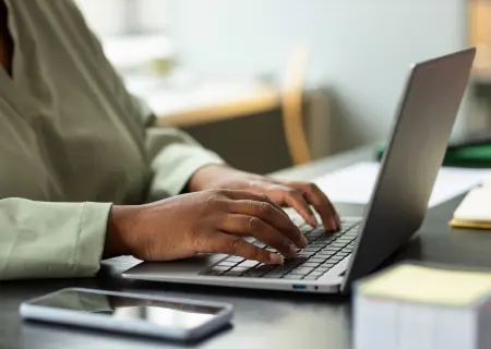 Profissional mexendo no laptop reorganizando escala considerando ausências por atestado médico - Imagem de Freepik