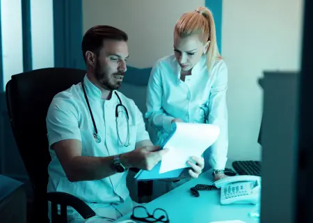 Médicos trabalhando em horário noturno e conversando - Imagem: Freepik