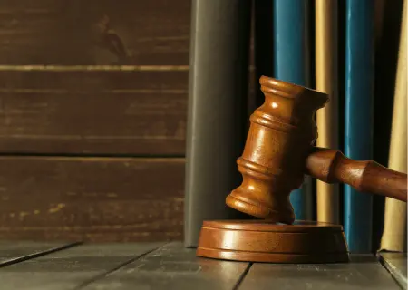 Martelo de juiz em frente a livros - Imagem: Magnific