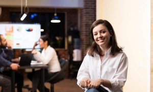 Mulher sentada em escritório sorrindo organizando capacity planning - Imagem de Magnific