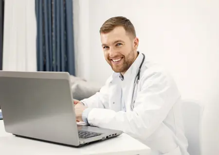 Médico mexendo no Escala no laptop vendo como permitir que os colaboradores escolham ou troquem de turno dentro de uma plataforma - Imagem de Magnific