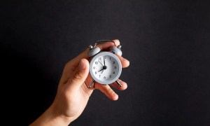 Pessoa segurando relógio indicando realização de hora extra obrigatório - Imagem de Magnific