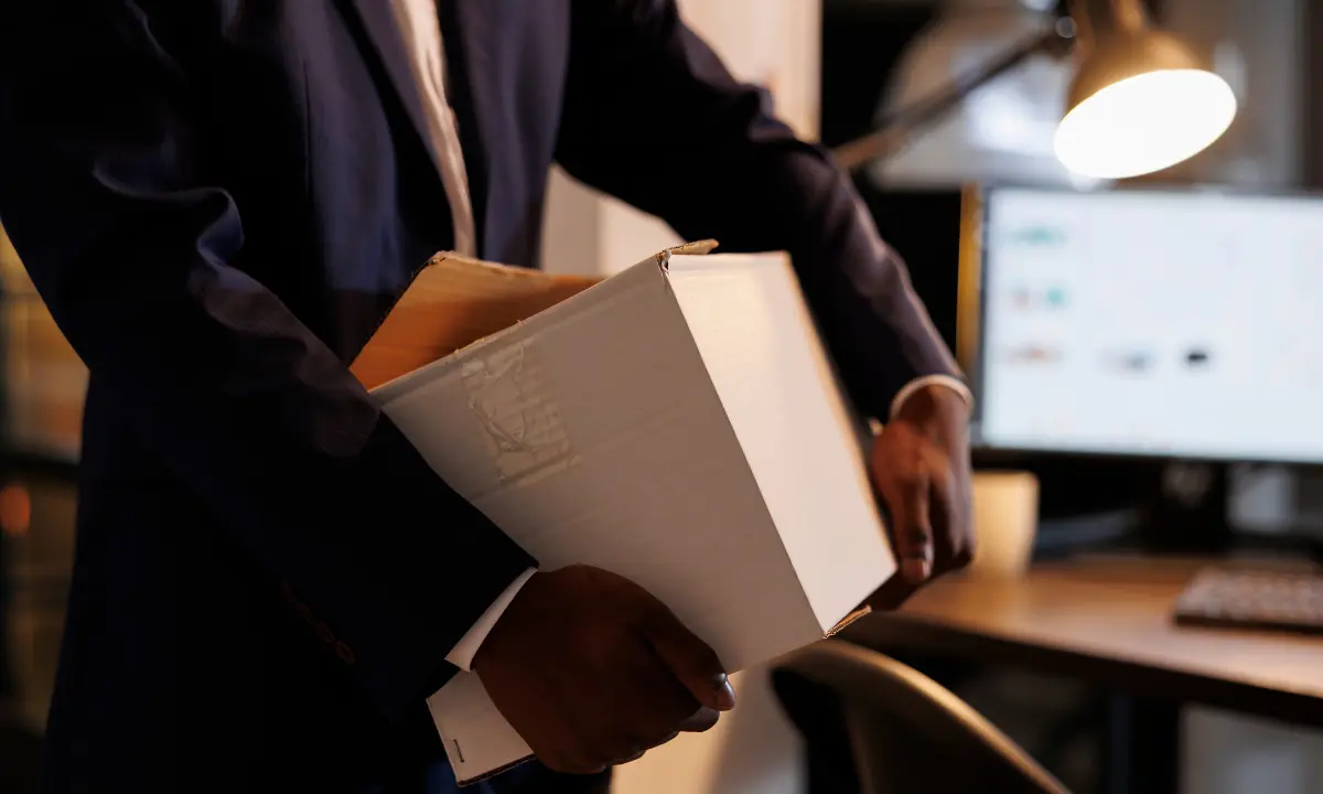Funcionário segurando caixa de papelão com seus pertences deixando o escritório, por desligamento - Imagem de Magnific